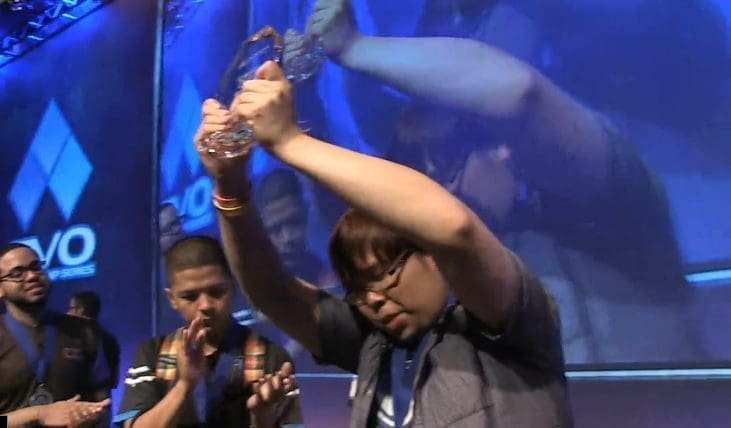 Justin Wong raises his first place trophy after his Ultimate Marvel vs. Capcom 3 victory.